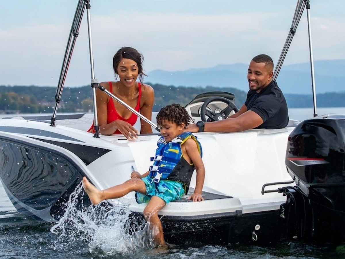 Todd Johnson riding on the back of a boat in a body of water