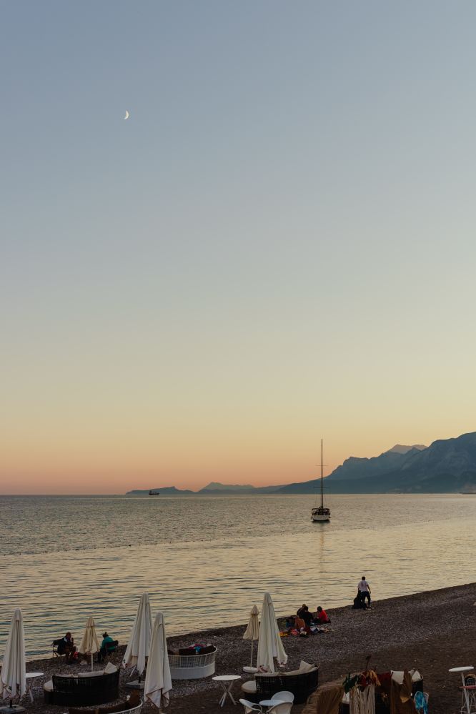 a group of people on a beach near a body of water